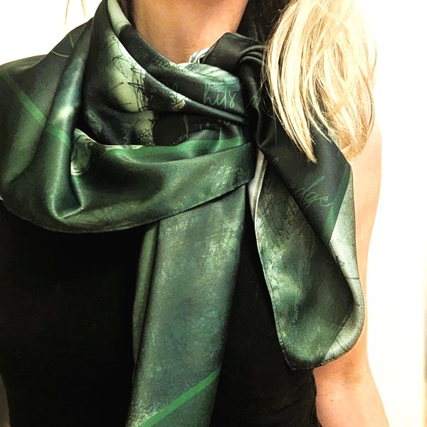 woman wears a beautifully draped sexy silk scarf in green around her throat neck and shoulders - very sophisticated